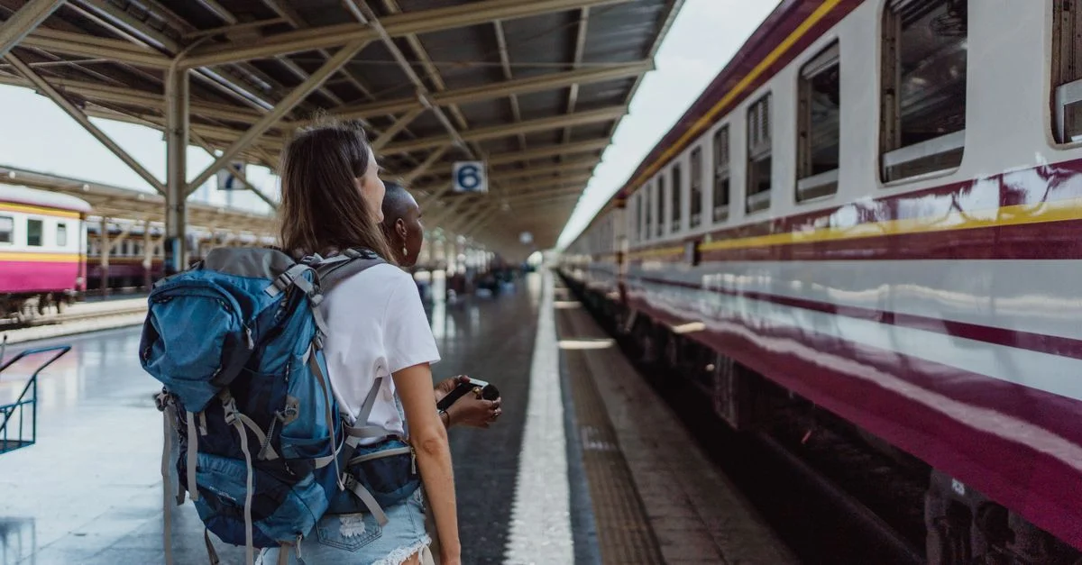 Deux femmes avec des sacs à dos attendant à une gare ferroviaire pour un train. Thème de voyage et d'aventure.