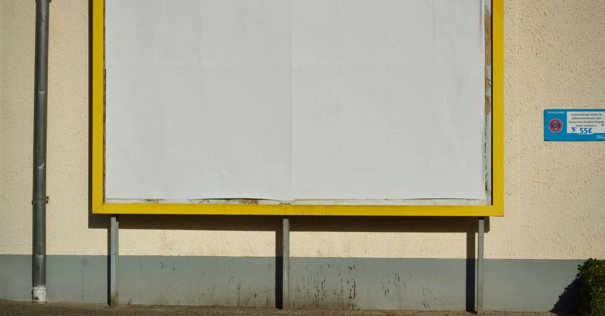 Panneau publicitaire vide dans une rue, avec un cadre jaune, idéal pour une maquette publicitaire.
