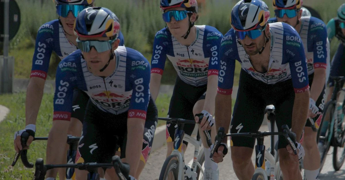 Des cyclistes professionnels participent à une course par équipes en journée, illustrant le travail d'équipe.