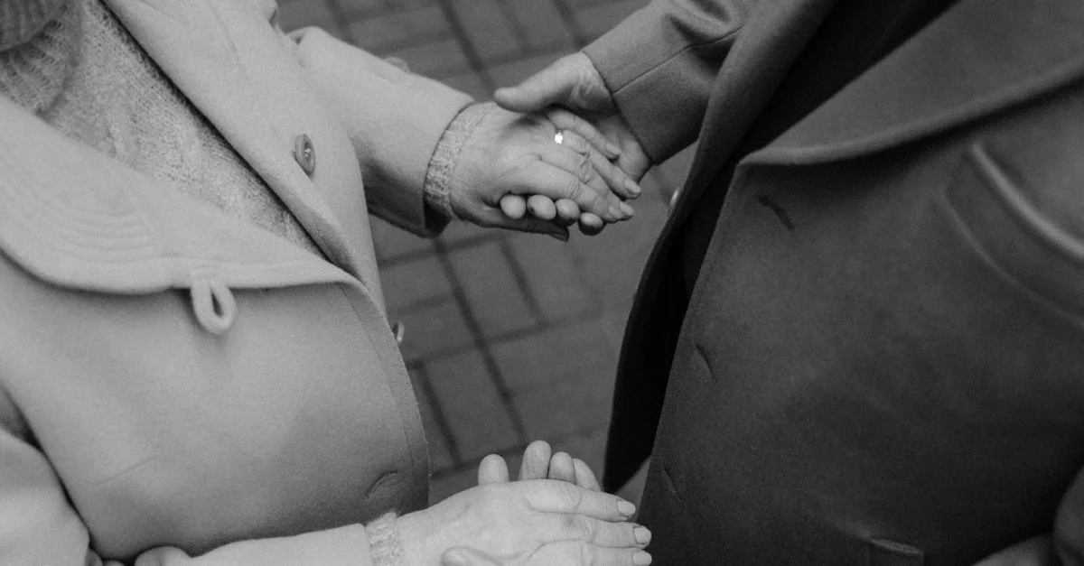 Une photo en noir et blanc en gros plan d'un couple âgé se tenant la main, symbolisant l'amour et l'affection.