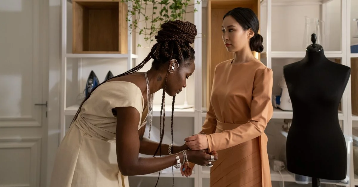 Une créatrice de mode ajuste la robe d'un modèle dans un cadre d'atelier. Capture parfaite de la créativité et de la concentration.